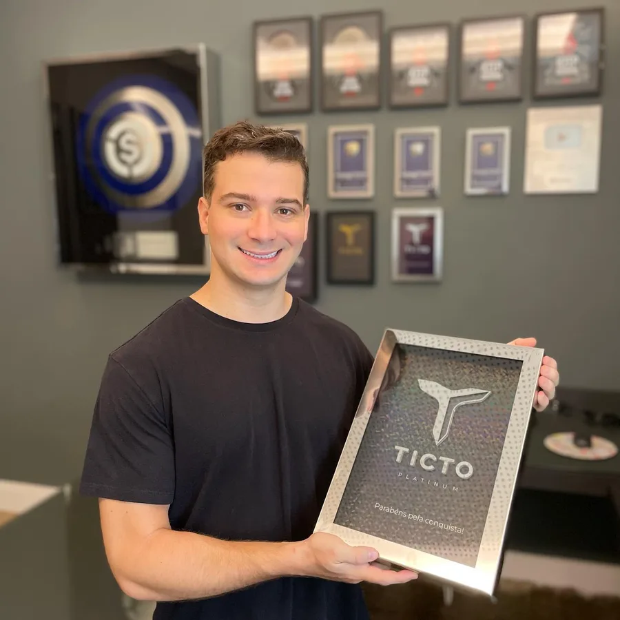 João Pedro Alves com o prêmio Ticto Platinum e a parede de placas